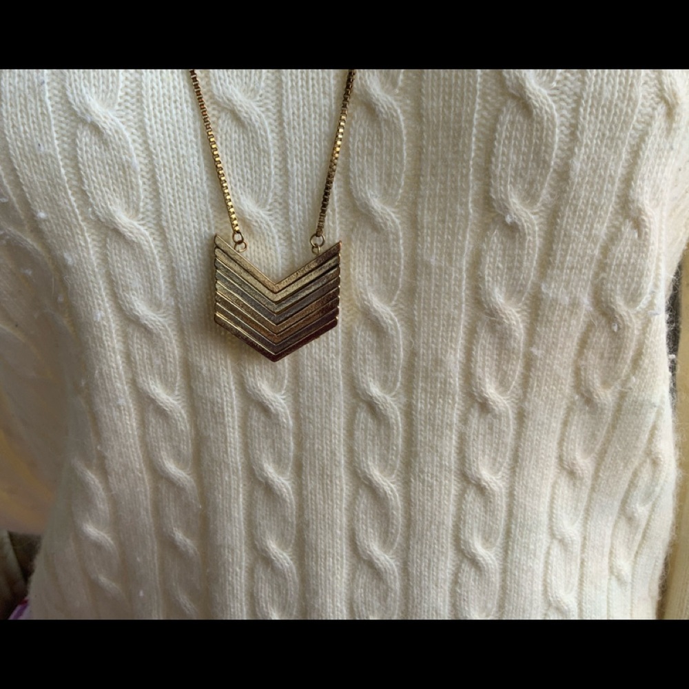 Long gold arrow necklace.